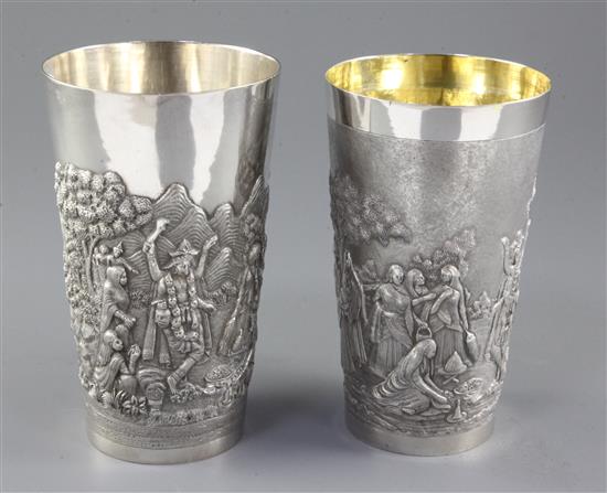 Two Indian white metal beakers, each embossed with scenes of women making offerings to Lord Shiva